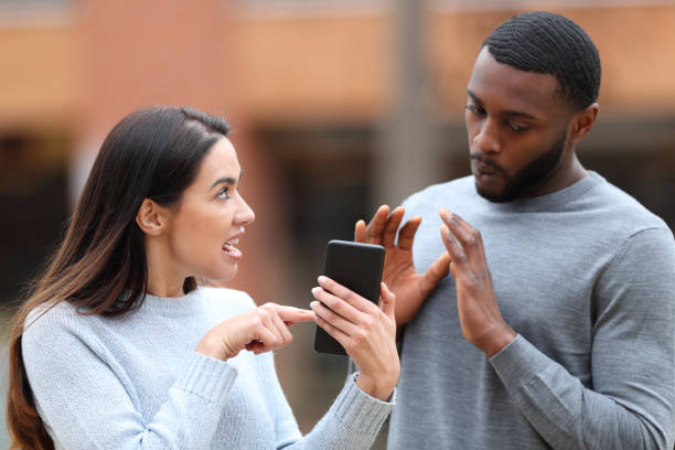 istock Angry woman scolding a man showing phone content 1496435662