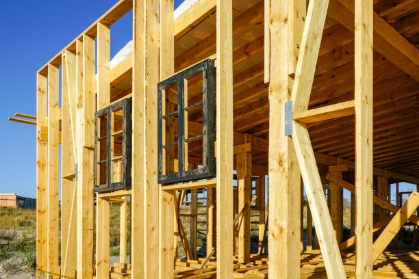 istock New unfinished natural wood building framework facade fragment on blue sky background 1496438935