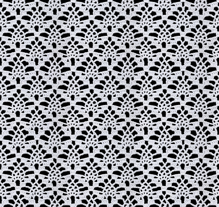 Snow white seamless knitted texture. Beautiful lace with a pattern in the form of openwork rhombuses is crocheted. Cotton yarn. Guipure on a black background.