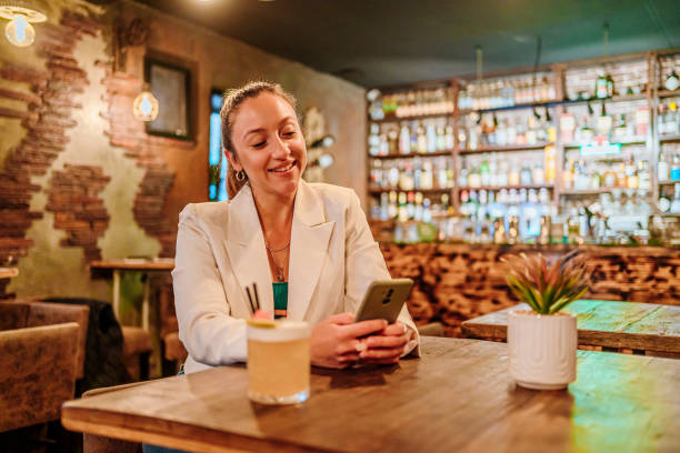 istock Woman using phone at the bar 1496441346