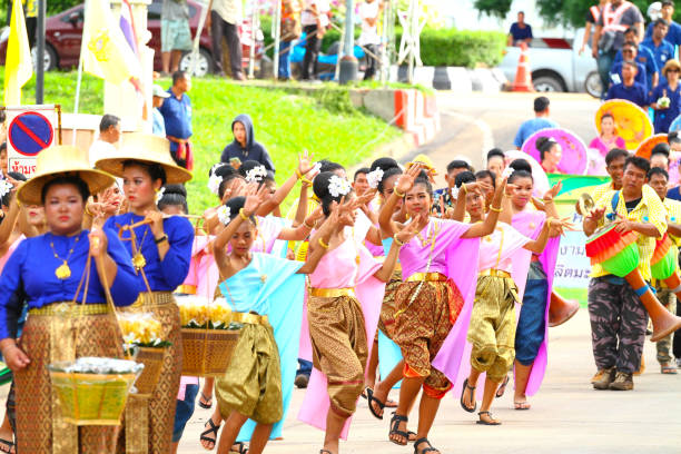 Young thai  dancer women Young thai  dancer women  following Traditionally  blue dressed thai farmer women with hat at  Public local traditional culture event organized by local government near historical grounds of Wat Wihan Thong Historical Site near Nan river and is local way of keeping history and traditions alive. Farmer styled women  wearing classical bamboo hats are walking ahead and and are by  young women are dancing rum thai true thailand classic stock pictures, royalty-free photos & images