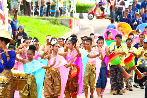 Capture of young thai  dancer women  traditionally   dressed Capture of young thai  dancer women  traditionally   dressed  at  Public local traditional culture event organized by local government near historical grounds of Wat Wihan Thong Historical Site near Nan river and is local way of keeping history and traditions alive. Women are part of larger groups and parade true thailand classic stock pictures, royalty-free photos & images