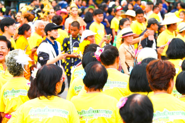 vista traseira sobre a multidão e cabeças de pessoas tailandesas vestidas de amarelo - true thailand classic - fotografias e filmes do acervo