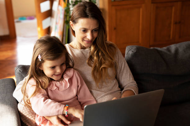 istock Beautiful girl watching cartoon with mom. 1496443507