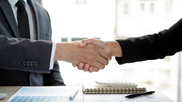 istock Two businessmen are shaking hand in the office room. 1496443875