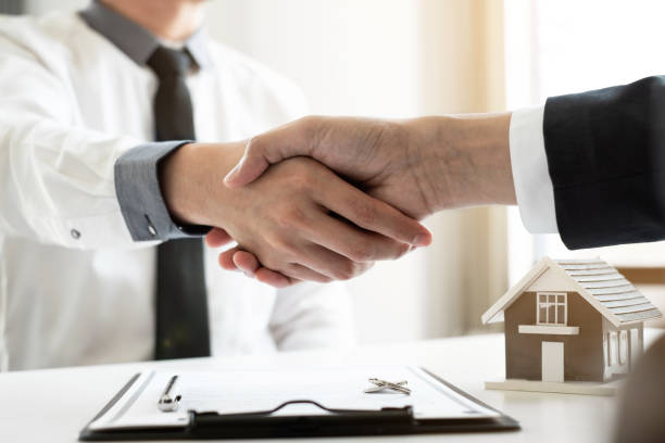 istock Home insurance agent shaking hand with the customer in the office. 1496446961