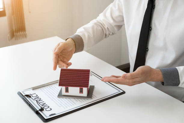 istock Home insurance agent presenting the home model in the office. 1496446975