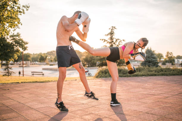 istock Female athlete practicing kickboxing with her boyfriend outdoors 1496448371