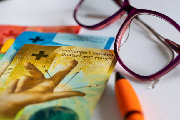 swiss francs money, women's glasses, white sheet of paper, pen, concept, bill payments, installments and credits, rising household budget costs in switzerland - swiss currency franc sign switzerland currency imagens e fotografias de stock