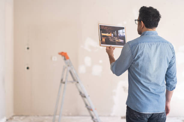 istock Man in glasses holding picture in hand looking at loft interior design 1496453010