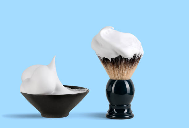 Shaving brush and shaving foam isolated on a blue background