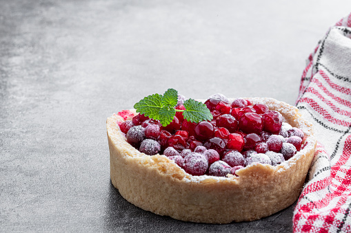 Tasty  homemade cranberry pie on gray background