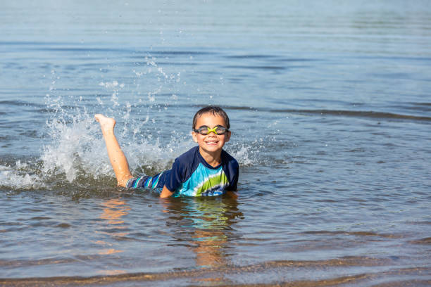 istock Boy Splashing In Shallow Water at Beach 1496463524