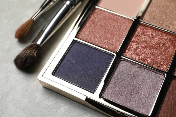 istock Beautiful eye shadow palette and brushes on grey table, closeup 1496466040
