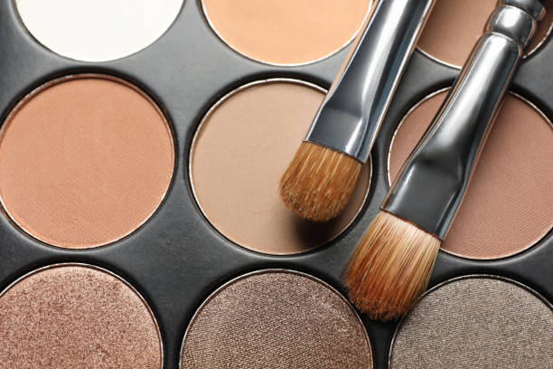 istock Beautiful eye shadow palette and brushes as background, top view 1496466253