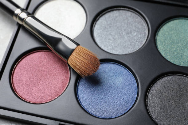istock Beautiful eye shadow palette and brush on grey table, closeup 1496466364