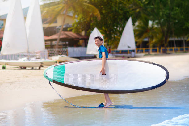 istock Child on stand up paddle. Water and beach sport 1496466379