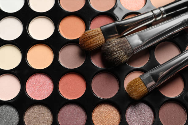 istock Beautiful eye shadow palette with brushes as background, top view 1496466418