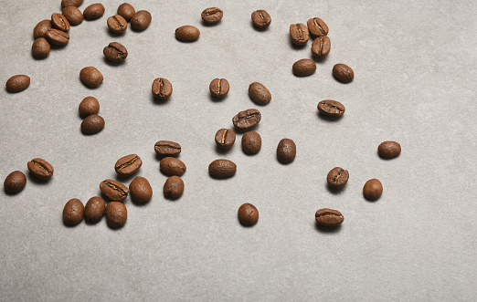 Coffee beans on the ceramics stone background with copy space