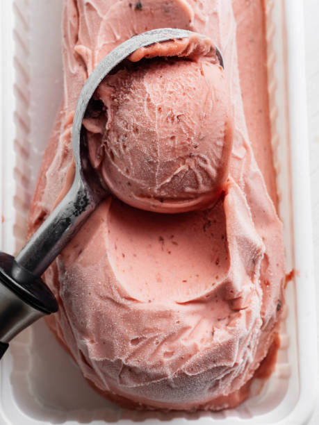 Strawberry Ice Cream, Sorbet, Metal scoop scrapes ice cream from the box, Strawberry ice cream with ice cream scoop, Ice cream stock photo