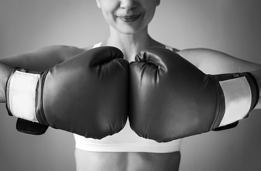 Young athletic woman having a boxing training in a gym and smiling.