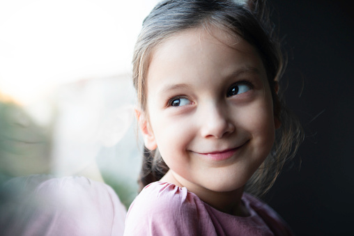 The portrait of two emotional happy surprised girl and serious angry girl on a white and black studio background. Human emotions concept. Comparison of different emotions. The childhood, kid, friendship concept