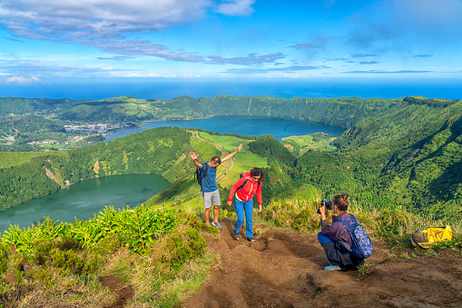 Three tourists at the viewpoint around the caldera on São Miguel island in the Azores