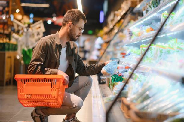 istock Man buying vegetables and fruit in reusable bag in grocery store, zero waste concept 1496471695