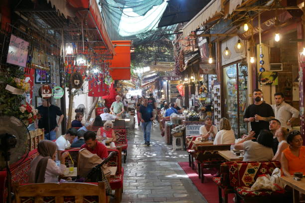 Men and women enjoying drinks in the busy bazaar stock photo