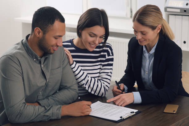 istock Professional notary helping couple with paperwork in office 1496473483