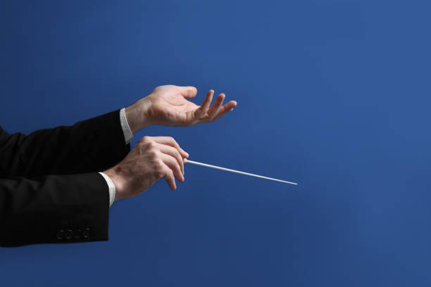 istock Professional conductor with baton on blue background, closeup 1496473514