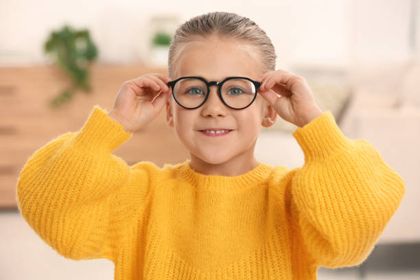 portrait of cute little girl wearing glasses indoors - primary care imagens e fotografias de stock
