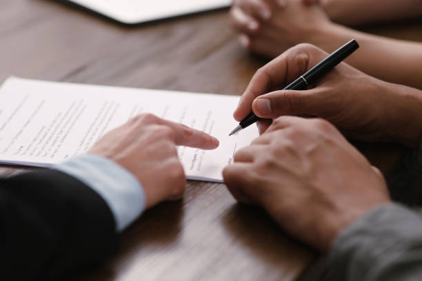 istock Notary helping couple with paperwork at wooden table, closeup 1496473661