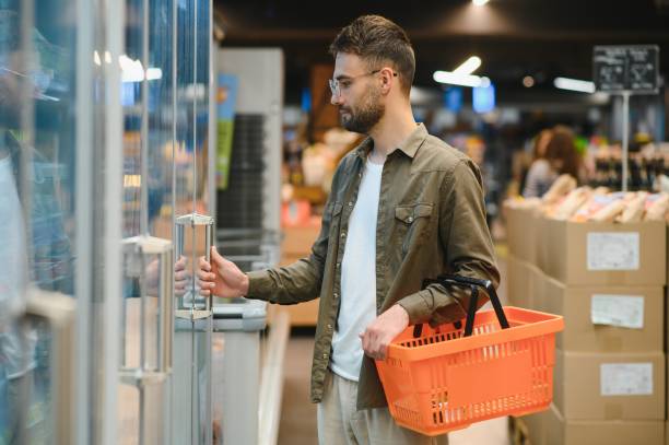 istock Handsome young man choosing food in the supermarket. 1496473708