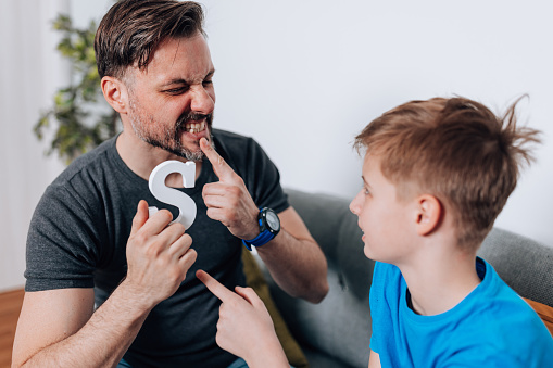 Discover the impact of focused speech therapy sessions as a mid adult speech therapist enhances the articulation and pronunciation skills of a male child in the familiar living room setting