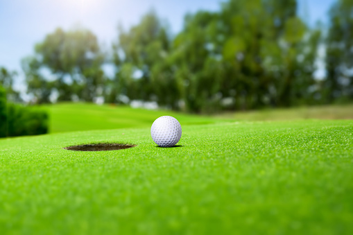 Golf ball on green grass playing field