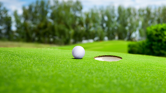 Golf ball on green grass playing field