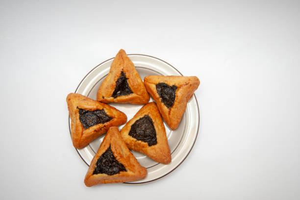 istock Five pies with poppy seeds on a plate on white background. 1496477772