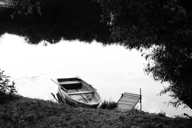 Boot am Flussufer Ein einsames Boot liegt am Flussufer der Mulde, einem uralten Flussstrom im Herzen Deutschlands. grimma stock pictures, royalty-free photos & images