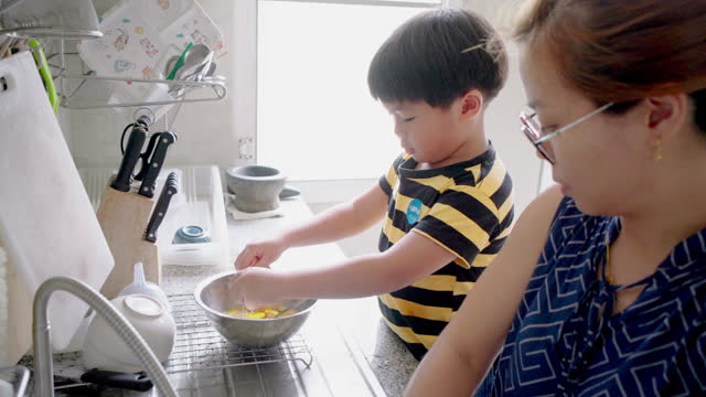 Asian family enjoys cooking together in the kitchen at home