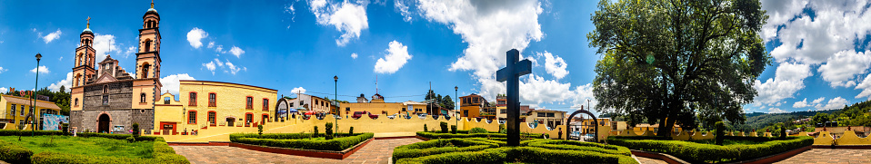 Iglesia amarilla con jardín en pueblo rural, día soleado, parroquia de el oro de Hidalgo estado de México