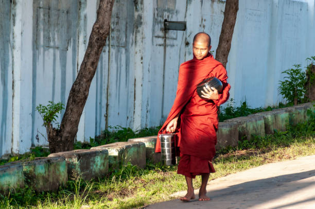 Pagan, Myanmar - August 14, 2015: monk in traditional dress uses a mobile or smart phone to get contact.