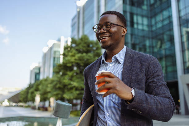 istock Modern young African American businessman with longboard 1496484059