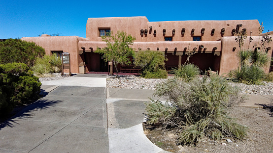 Taos NM, USA -April 15, 2023: The Southwest of the US is home to some very unique architecture. Local materials  and adobe building style characterize the majority of the building in the Southwest. The image was captured in  the old town plaza in Taos, New Mexico and shows a second story adobe structure.