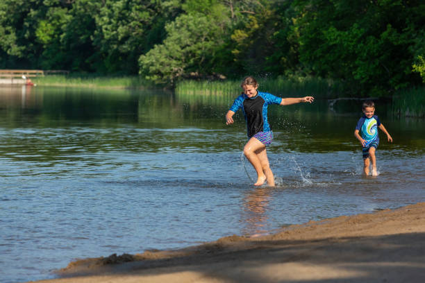 istock Girl & Boy Running Through Water At Beach 1496489963