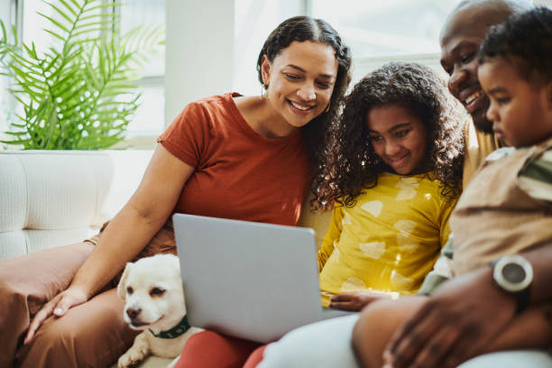 istock A young family of four is sitting and smiling while using the laptop computer. Stock photo 1496491663