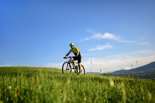 Mountain biker rides in mountain meadows.