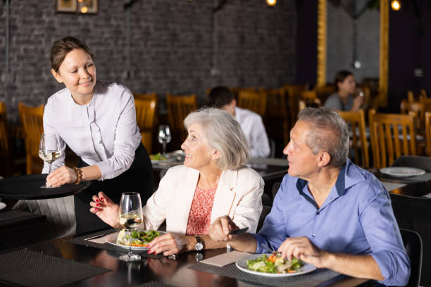 istock Female hostess serves puts on table order for elderly spouses 1496495988