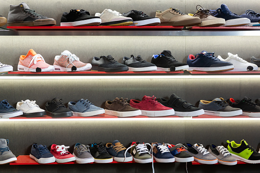 A lot of casual men shoes on shelves in shoe store