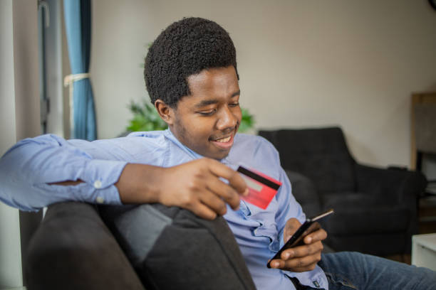 istock Cheerful man doing online shopping 1496507807
